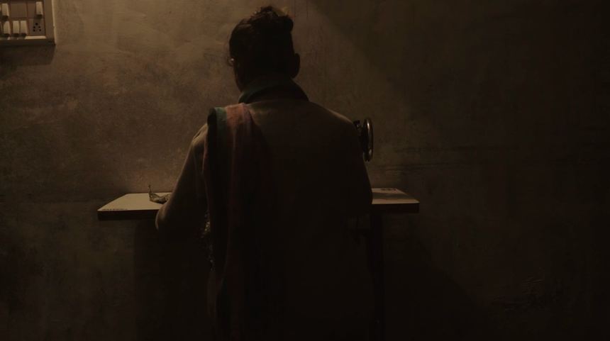 Silhouette of a woman at a sewing machine